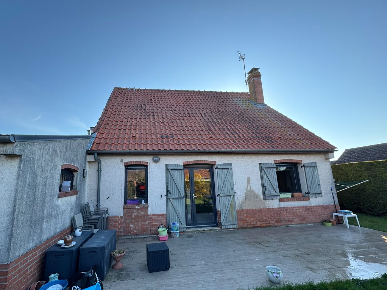 Maison avec toiture encrassée et façade défraîchie avant nettoyage